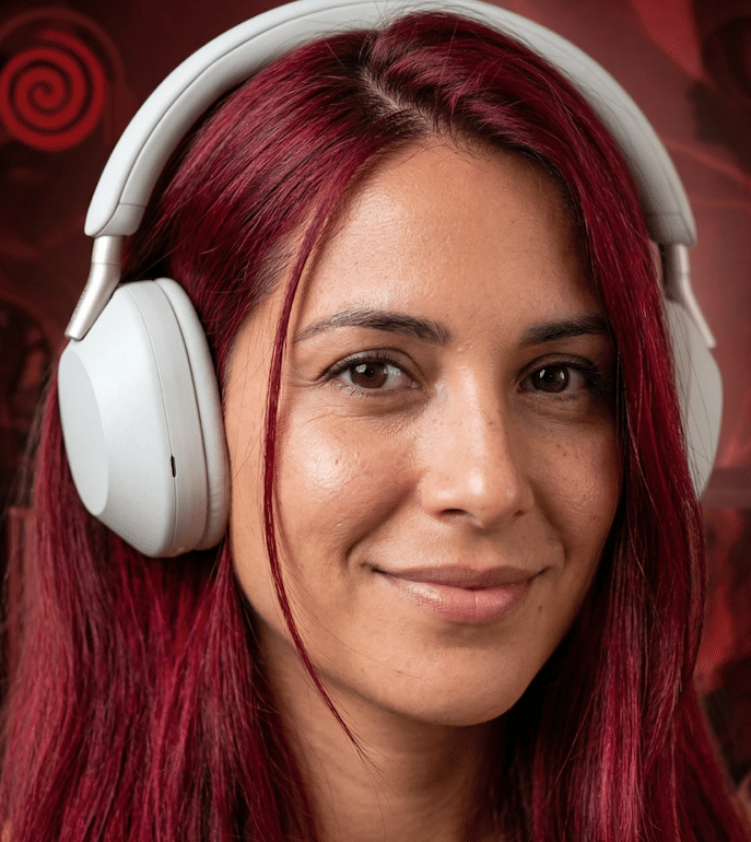 Una chica con el pelo rojo está escuchando el audiolibro Sin bragas no hay miedo con unos auriculares blancos.